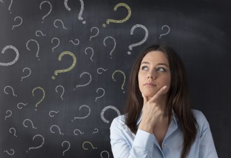 Businesswoman and question mark on blackboard